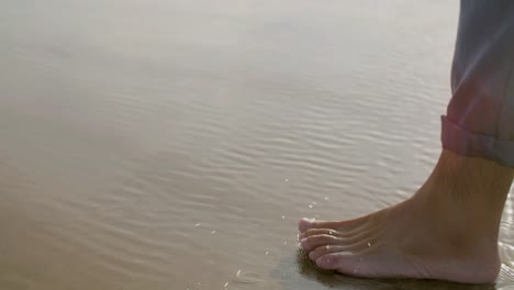 Legs-closeup-of-Caucasian-man-walking-alone-seashore.