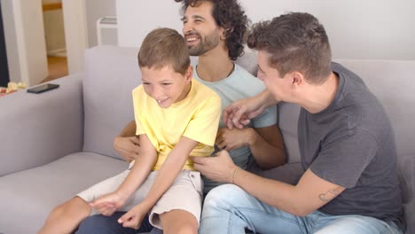 Joyful-gay-parents-and-kid-having-fun-at-home