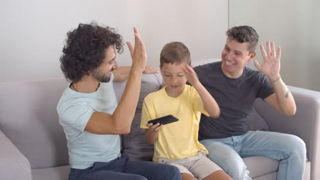 Fröhlicher-Nerdiger-Junge,-Der-Ein-Online-Spiel-Auf-Dem-Smartphone-Gewinnt