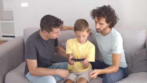 Two-dads-helping-son-to-play-online-game-or-using-app