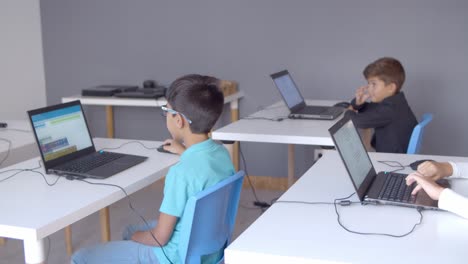 Kinder-Sitzen-An-Schreibtischen-Mit-Laptops-Im-Klassenzimmer