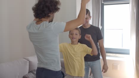 Cheerful-excited-gay-parents-and-kid-having-fun-at-home