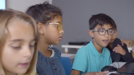 Kluger-Schuljunge-Mit-Brille-Hilft-Klassenkameraden-Bei-Der-Erledigung-Von-Aufgaben