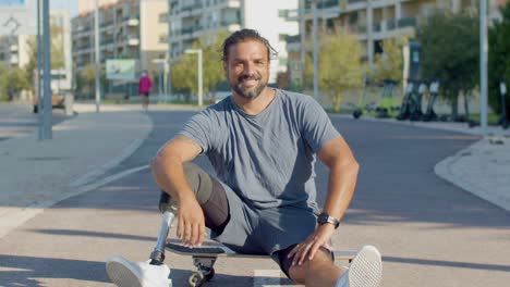 Portrait-of-happy-skateboarder-with-prosthetic-leg-on-board