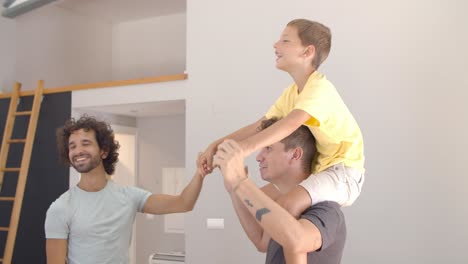 Cheerful-excited-boy-riding-on-dads-necks