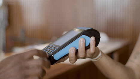 Closeup-of-mans-hand-inserting-credit-card-in-terminal.