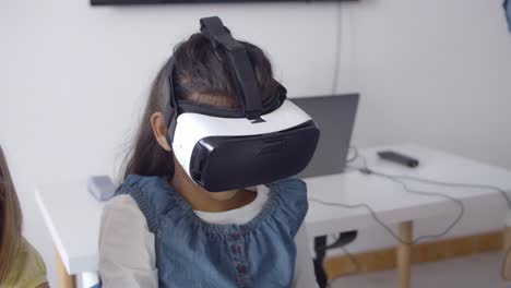 School-girl-in-VR-goggles-sitting-at-desk
