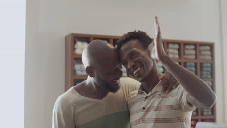 Black-male-couple-embracing-each-other-and-waving-goodbye.
