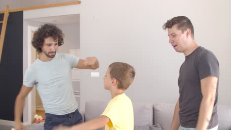Cheerful-gay-parents-teaching-son-to-dance-at-home