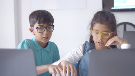 Boy-and-girl-in-glasses-collaborating-on-class-project