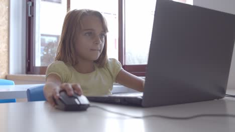 Schoolgirl-sitting-at-desks-with-laptop