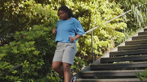 Long-shot-of-woman-running-down-stairs-in-public-park