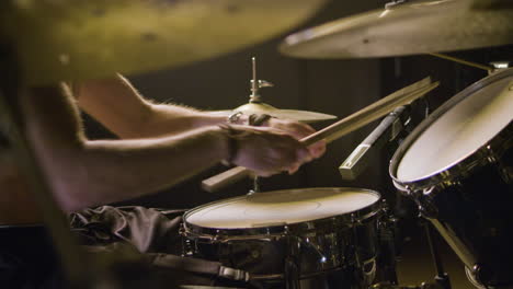 Young-male-drummer-playing-drums-at-music-studio