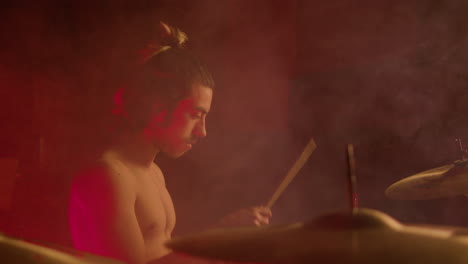 Young-shirtless-drummer-playing-drums-at-concert-show-on-stage