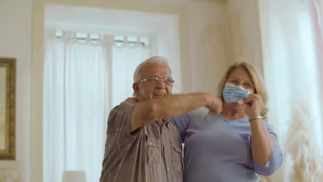 Senior-couple-happily-taking-off-their-masks-after-vaccination
