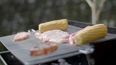 Close-up-of-hot-barbecue-grill-with-corn,-meat-and-sausages