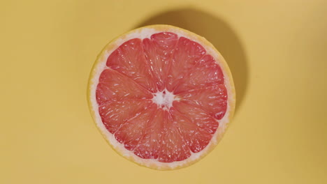 Top-view-shot-of-red-orange-on-isolated-yellow-surface