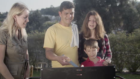 Happy-family-cooking-vegetables-on-barbecue-grill-outdoors