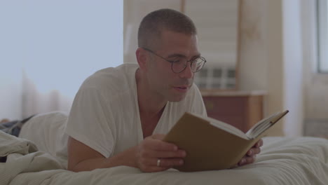 Schöner-Mann-Mit-Brille,-Der-Morgens-Im-Bett-Ein-Buch-Liest