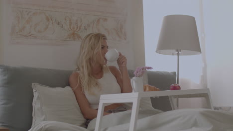 Beautiful-Caucasian-woman-having-breakfast-in-bed-at-home
