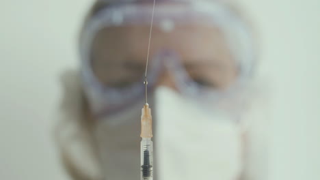 Close-up-shot-of-doctor-throwing-vaccine-out-of-syringe