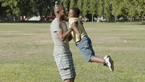 Father-lifting-his-son-under-armpits-and-spinning-round.