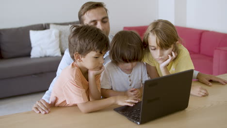 Ernsthafter-Vater-Und-Kinder,-Die-Gemeinsam-Einen-Film-Auf-Dem-Laptop-Schauen