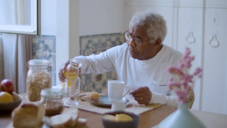 Black-elderly-man-enjoying-breakfast-at-home.