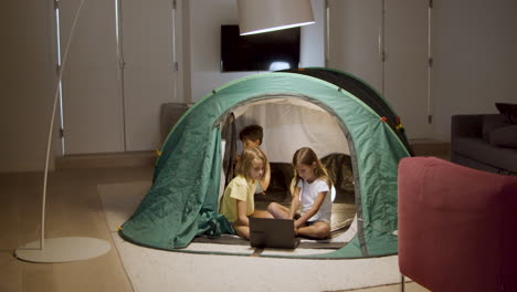 Kids-watching-movie-on-laptop-in-tent