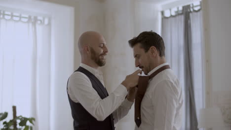 Handsome-Caucasian-gay-tying-his-lover-tie-for-wedding-ceremony