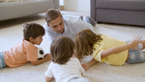 Dad-and-sibling-kids-lying-on-warm-floor