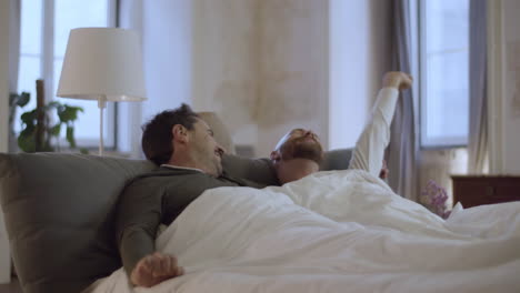 Handsome-Caucasian-men-lying-in-bed-in-morning-and-kissing