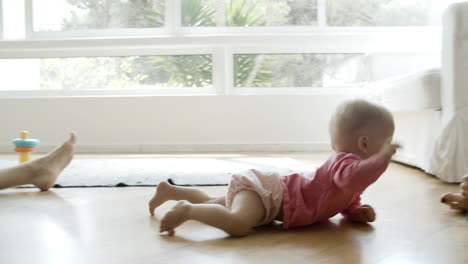 Cute-baby-crawling-on-floor-from-mom-to-dad-and-grasping-phone