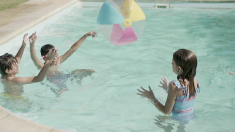 Children-playing-with--inflatable-ball-in-swimming-pool-outside.