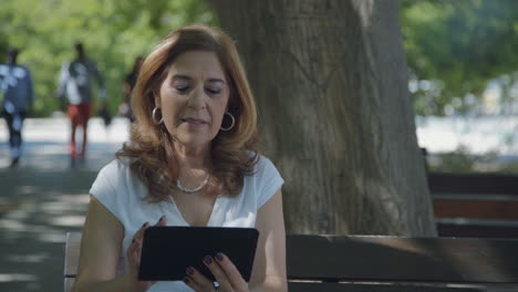 Woman-googling-on-tablet,-nodding-head,-looking-satisfied