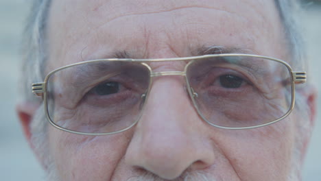 Nahaufnahme-Der-Augen-Eines-Alten-Mannes-Mit-Brille,-Der-In-Die-Kamera-Blickt