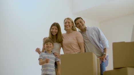 Glückliche-Familie-Steht-Im-Neuen-Haus-Und-Lächelt-In-Die-Kamera