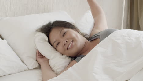 Plano-Medio-De-Una-Mujer-Japonesa-Feliz-Despertando-Y-Estirándose