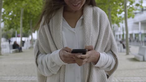 Smiling-mature-woman-holding-smartphone
