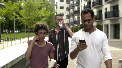 Entspannte-Menschen,-Die-Smartphones-Benutzen,-Während-Sie-Auf-Der-Straße-Gehen