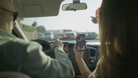 Couple-using-smartphone-with-map-in-car