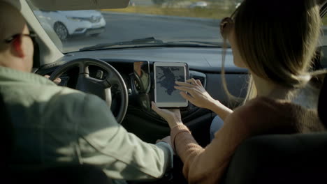 Couple-using-digital-tablet-in-car