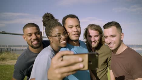 Happy-friends-running-to-smartphone-to-take-selfie