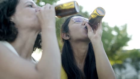 Cheerful-female-friends-drinking-beer