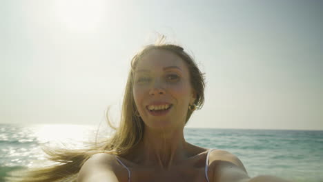 Happy-young-woman-turning-around-on-beach