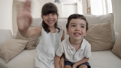 Two-cheerful-playful-kids-having-video-call