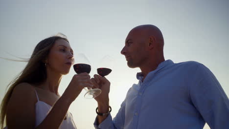 Couple-drinking-red-wine-at-sunset