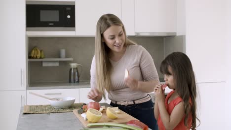 Mamá-Alegre-Y-Pequeña-Hija-Cortando-Manzanas-Frescas