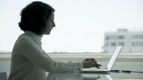 Thoughtful-businesswoman-using-laptop