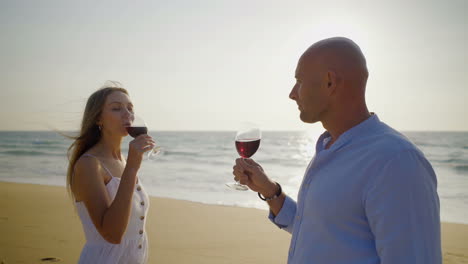 Young-couple-drinking-wine-on-beach